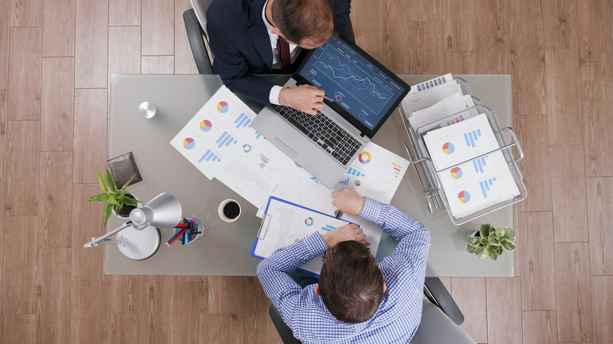 Top view of businessmen analyzing management statistics while working at company investments