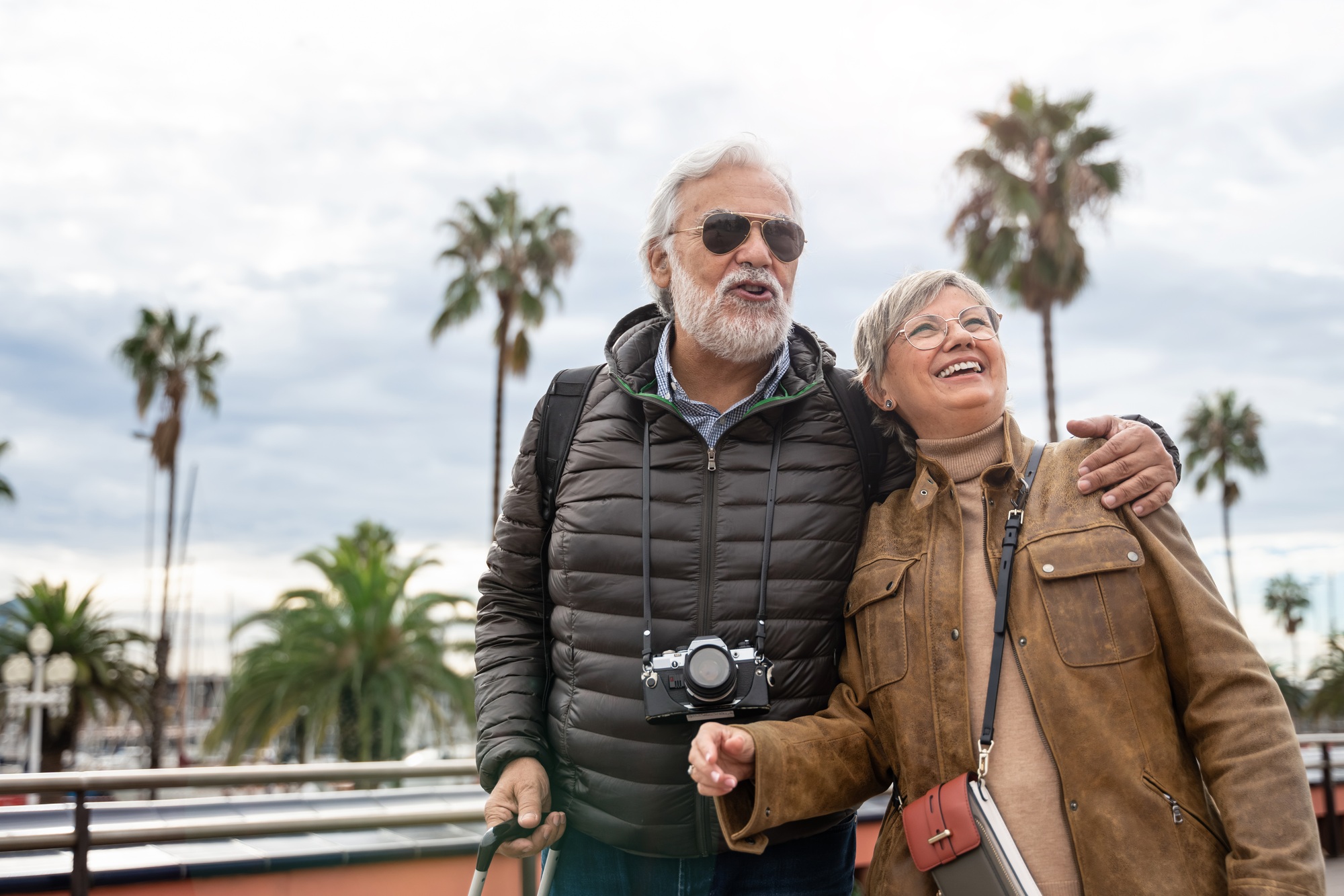 Happy old couple tourists traveling together - Grandpa and grandma on a retirement trip