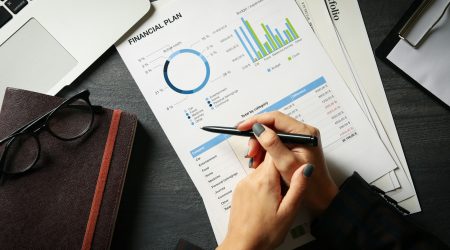 Business woman doing financial planning on black table with documents